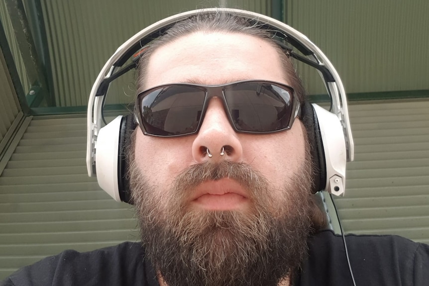 A man with headphones and sunglasses on his head.