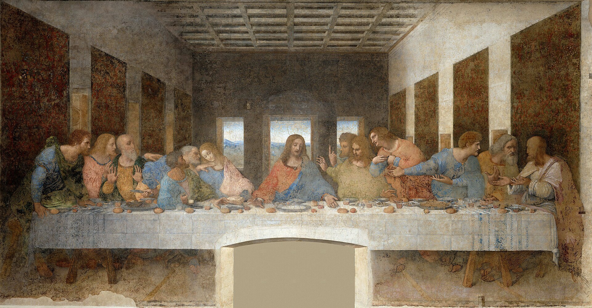 A 15th century painting 13 men in lively discussion seated along one side of a long table covered in food