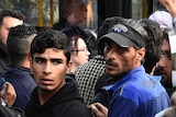 Refugees queue for bus in Berlin
