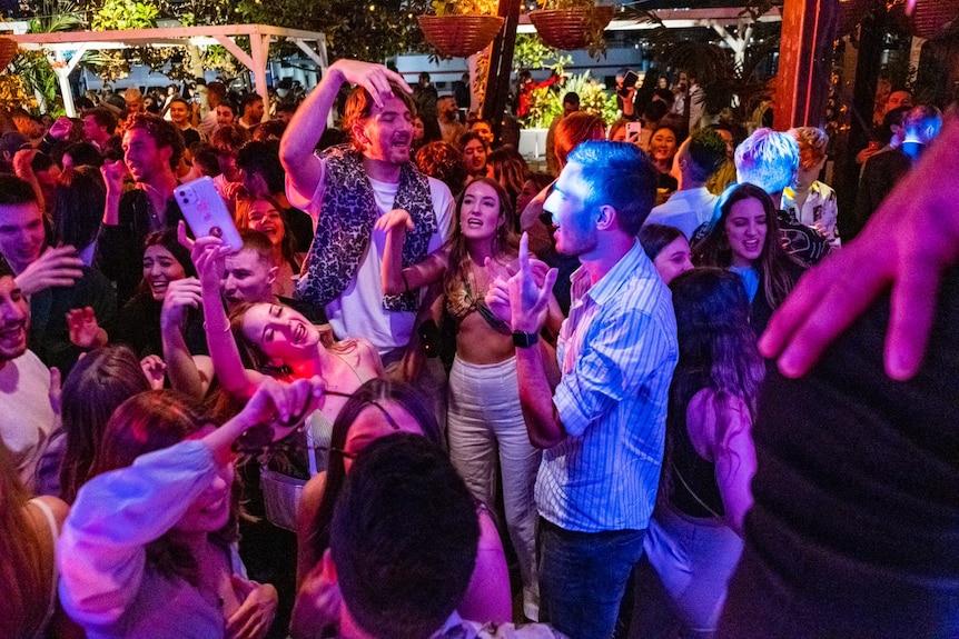 a group of people dancing and waving their arms