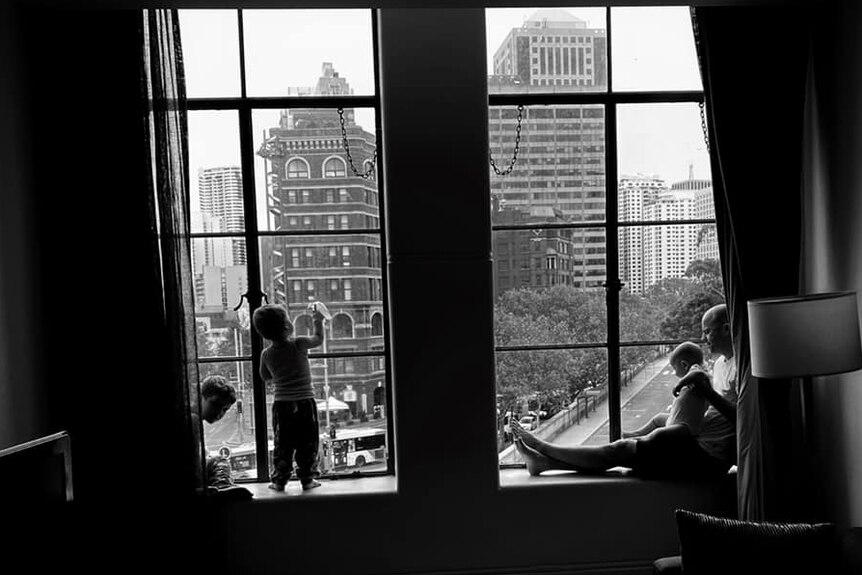 A family look outside of a window in a Sydney hotel