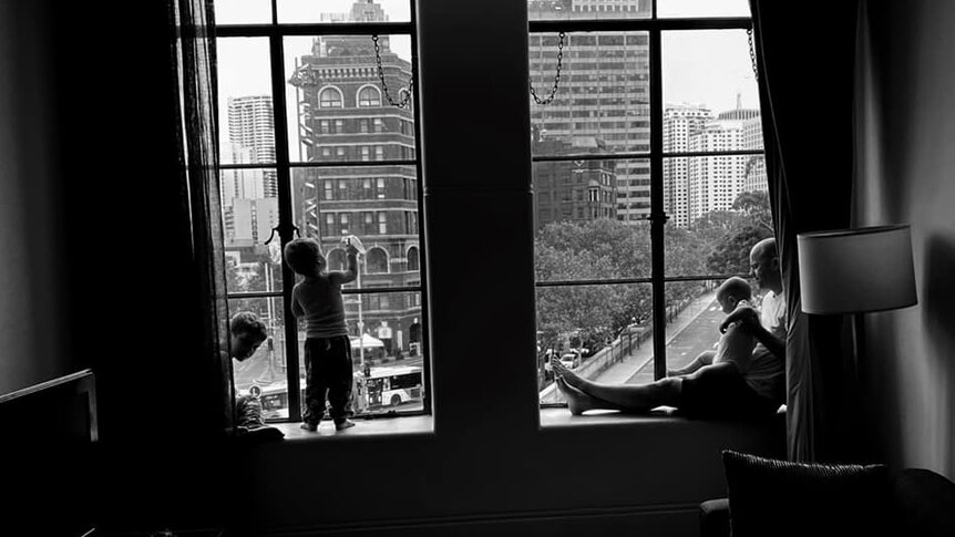A family look outside of a window in a Sydney hotel