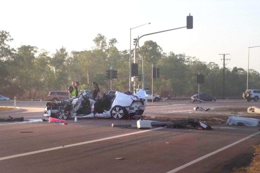 A smashed up white commodore sedan