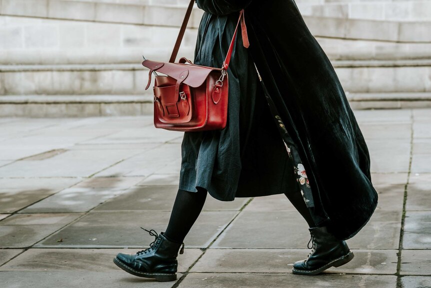 Image of woman from waist down carrying handbag to depict dramatic style.