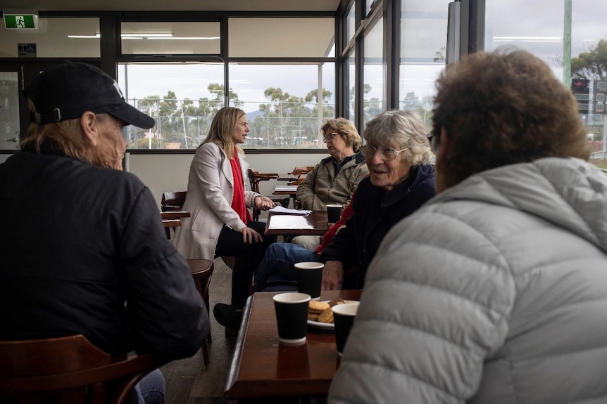 Rebecca White pictured talking with a woman with others in foreground.