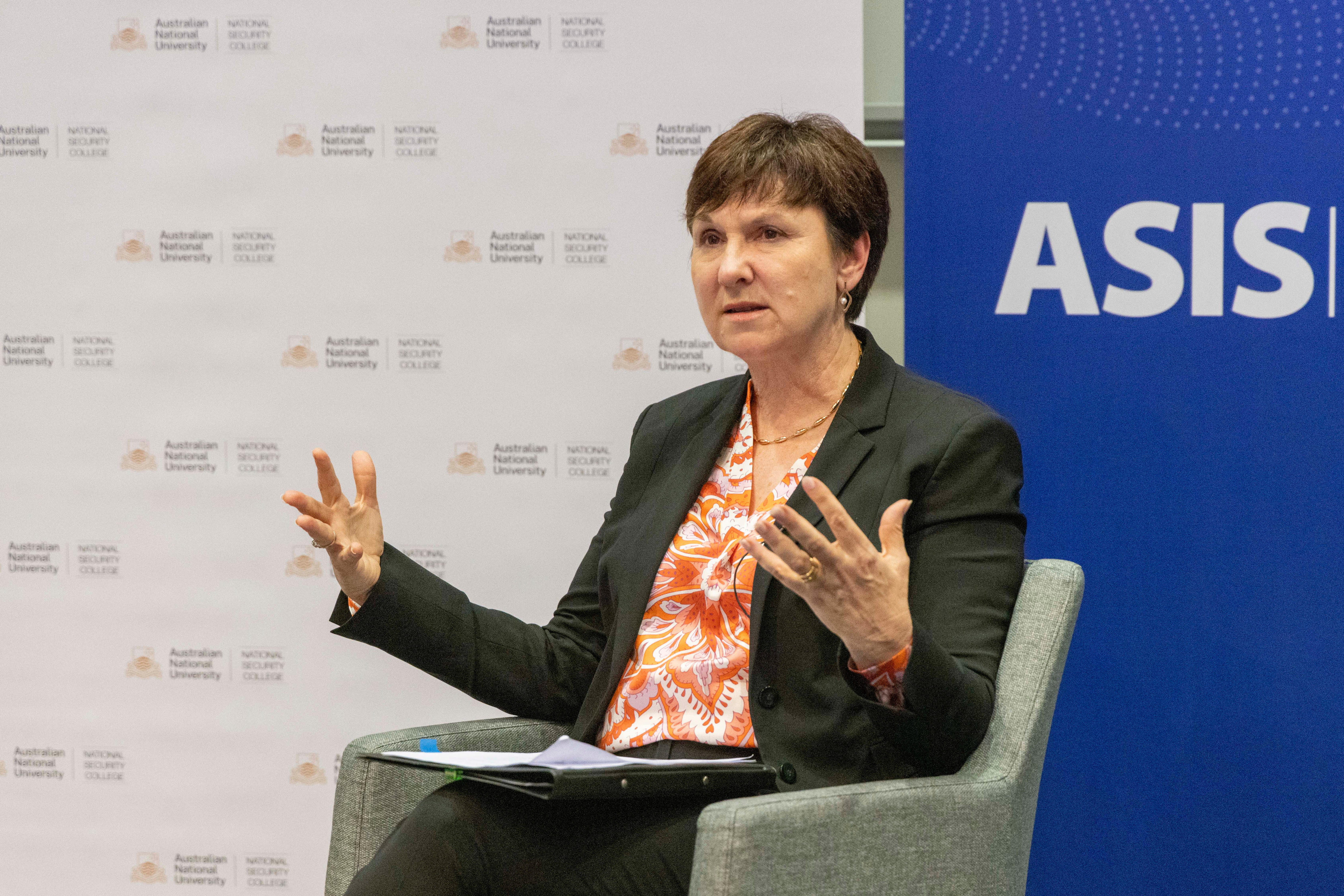 A women sits down and gestures with her hands 