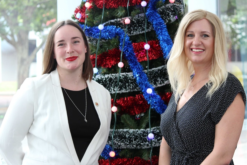 Aisling Blackmore and Dr Marny Lishman stand in front of a Christmas tree