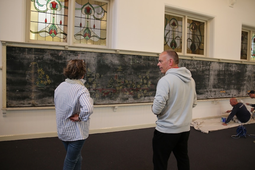 Peter deWacht in front of the chalkboard.