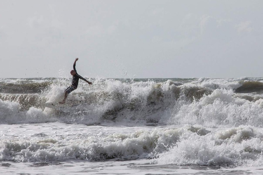 a surfer crashing through waves in swell