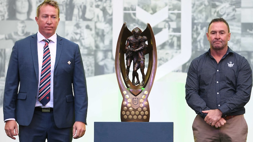 Trent Robinson and Ricky Stuart stand either side of the NRL premiership trophy