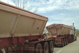 A road train hauls iron ore on the Stuart Highway