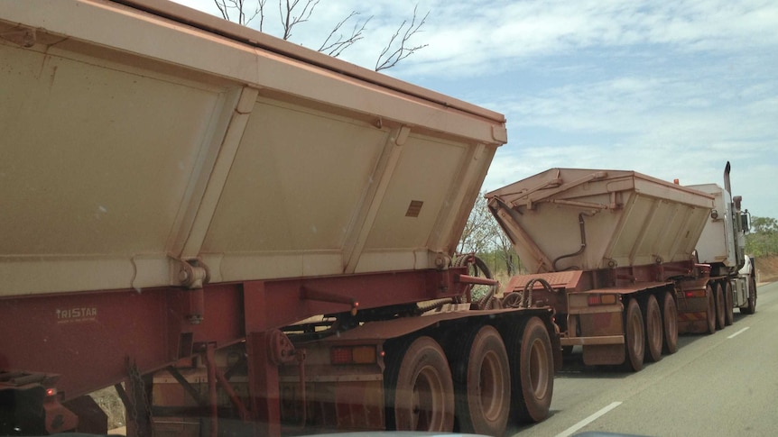 A road train hauls iron ore on the Stuart Highway