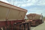 A road train hauls iron ore on the Stuart Highway