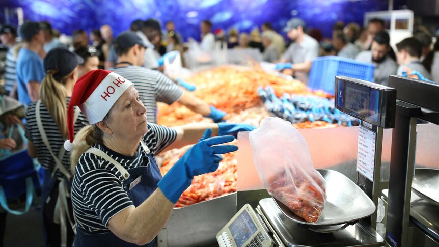 A woman weighing prawns at a fishmonger.