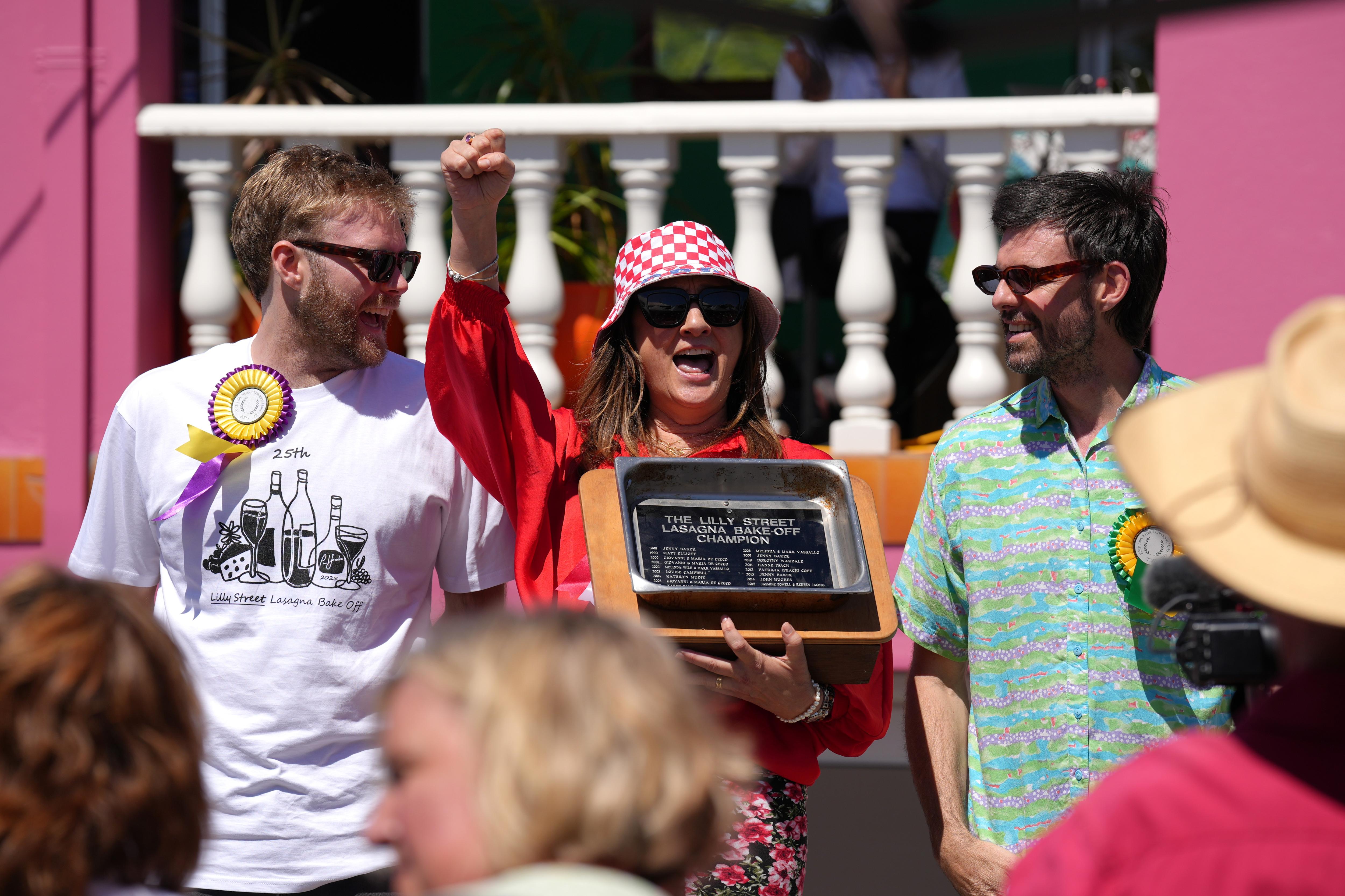 Melinda Blagaich, vestida de rojo y con una gorra de Croacia, sostiene un trofeo y celebra.