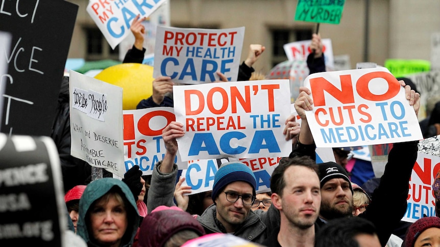Demonstrators hold signs reading "Don't repeal the ACA" and "No cuts to medicare"