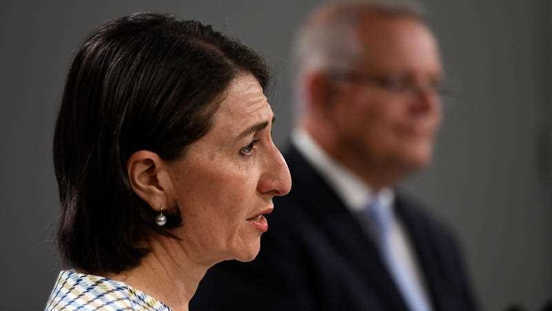 Gladys Berejiklian with Scott Morrison in the background.