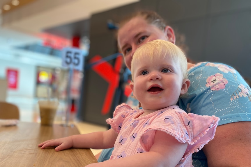 A mother with her infant daughter at a shopping centre cafe.