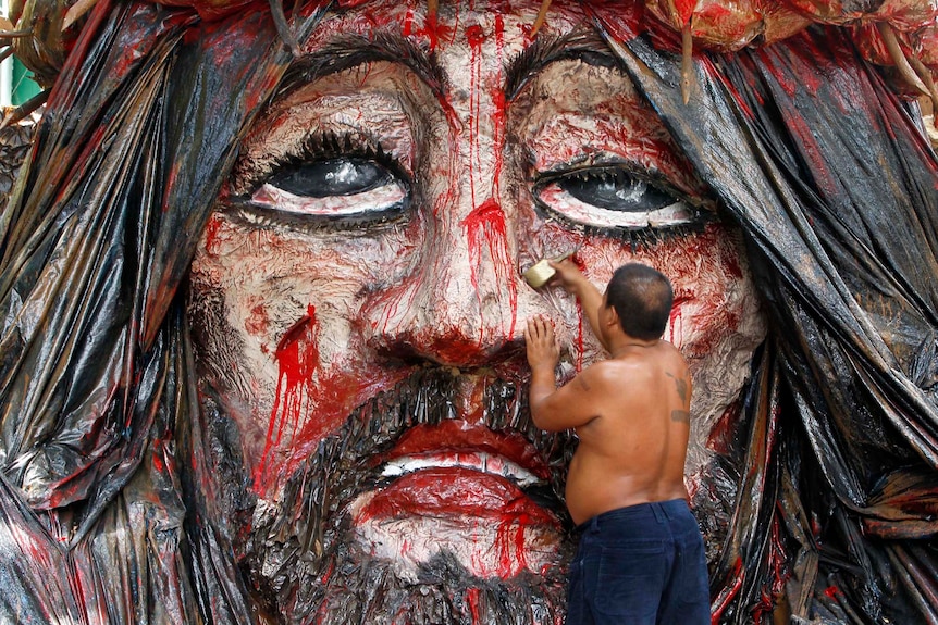 Manuel Revillon, 46, puts finishing touches on an image of Jesus Christ