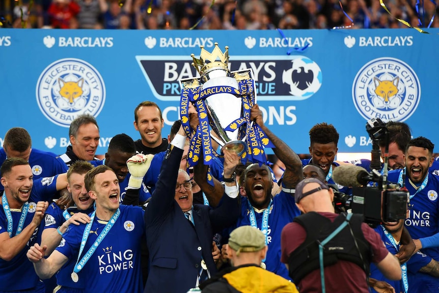 Players and the coach Ranieri hold up the trophy