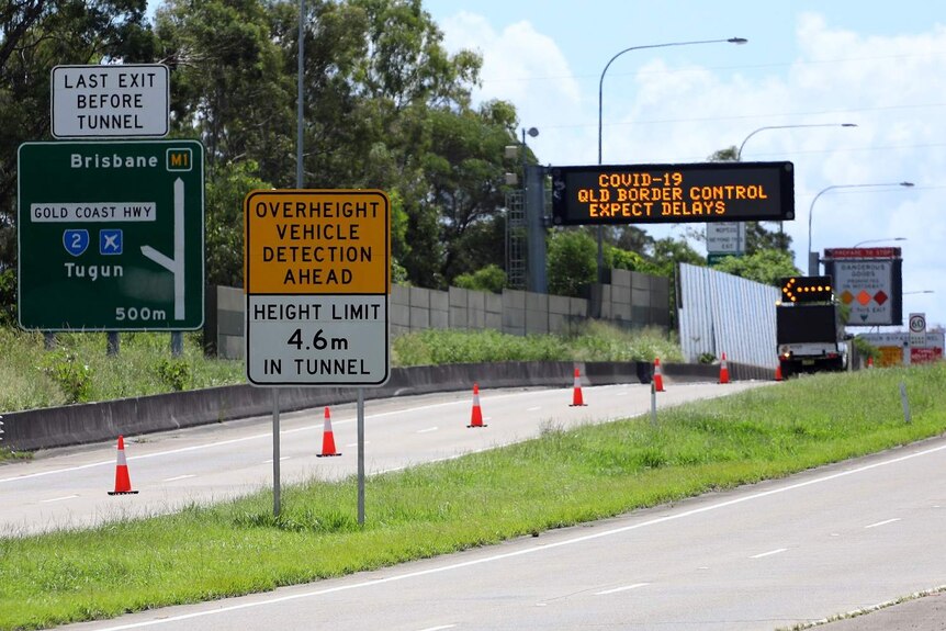 Motorway off-ramp with COVID-19 checkpoint signs at Queensland-NSW border at Coolangatta.