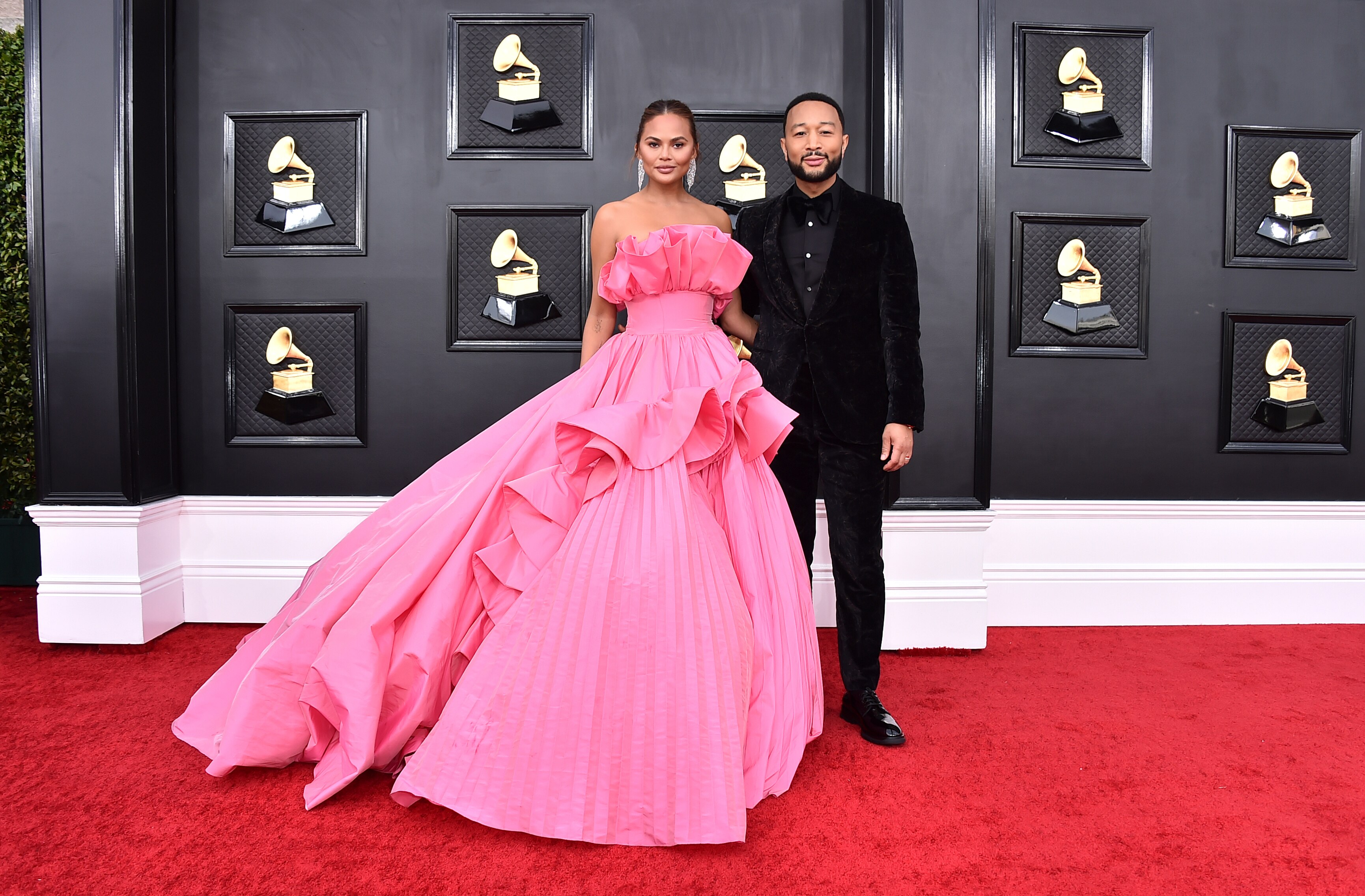 chrissy tiegen on the red carpet in a long full hot pink dress with john legend in a plain black suit