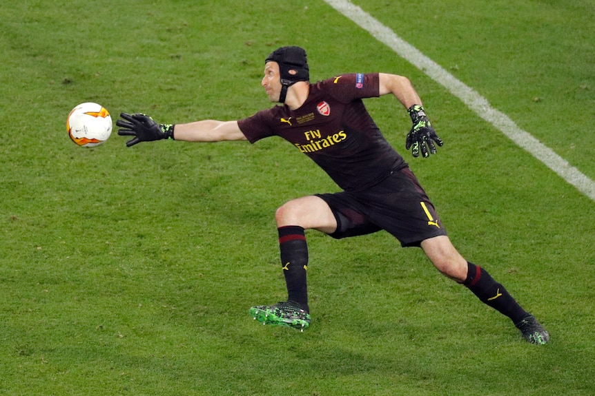 Former Chelsea goalkeeper Petr Cech reaches out with his right hand to stop the ball