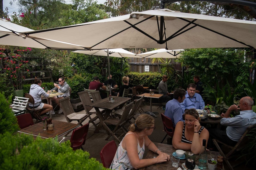 People sit in an outdoor cafe.