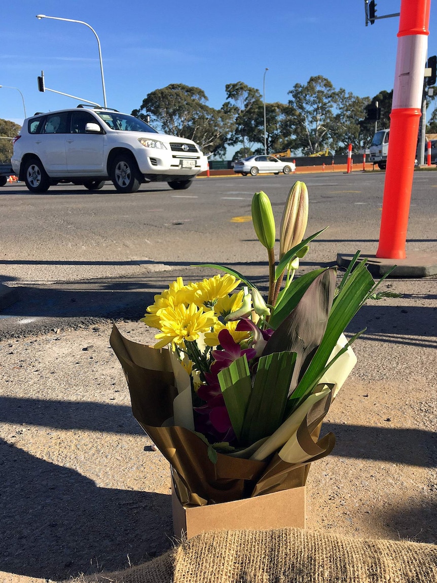 Flowers left on the side of the road where a man died in a crane accident.