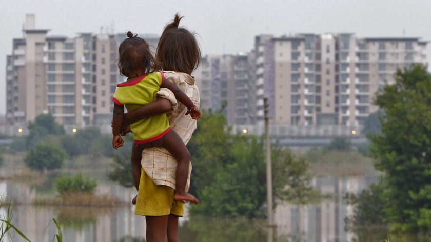 Girl and child stand near Delhi athletes village