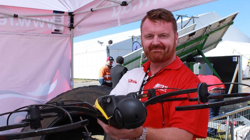 man holding drone in tent