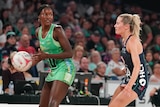 A West Coast Fever Super Netball player holds the ball while under defensive pressure from a Melbourne Vixens opponent.