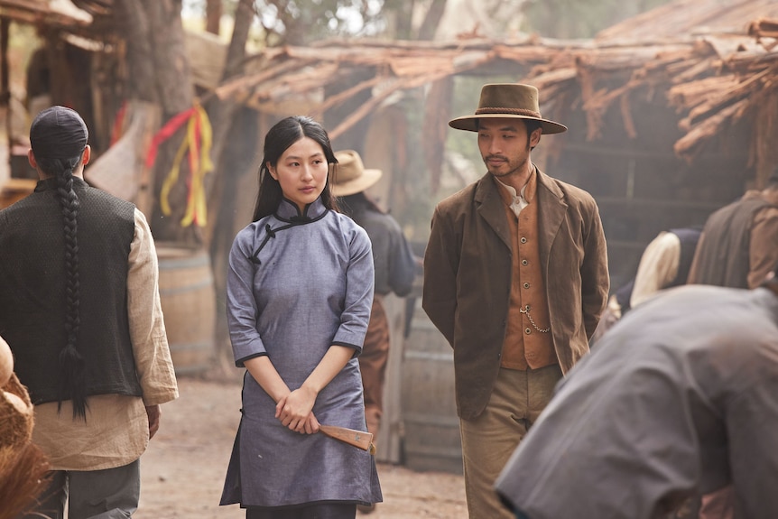 Two Chinese-Australians actors walk through an 1850s mining camp.