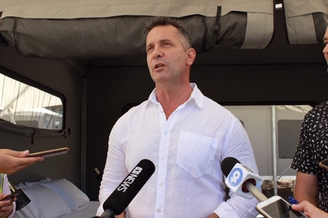 Paul Papalia stands in front of a glamping tent.