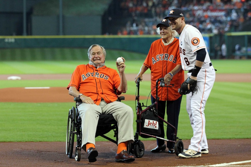 Former president George H.W Bush poses for a photo with his wife Barbara on the baseball field