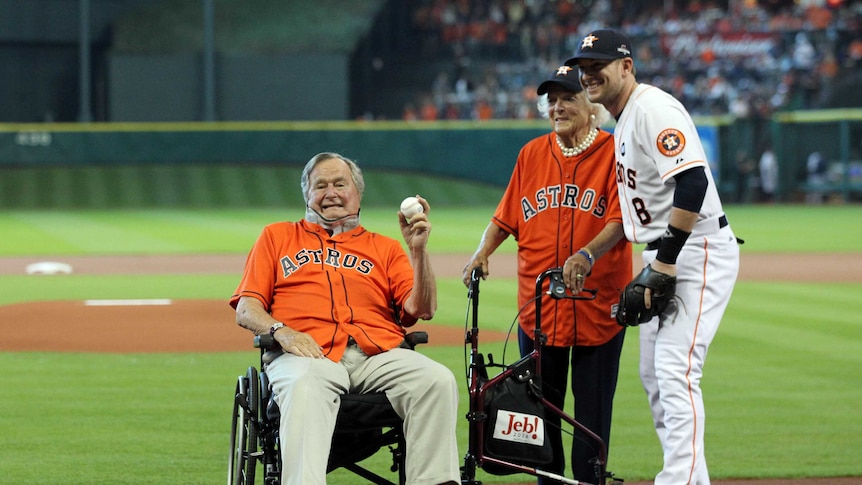 Former president George H.W Bush poses for a photo with his wife Barbara on the baseball field