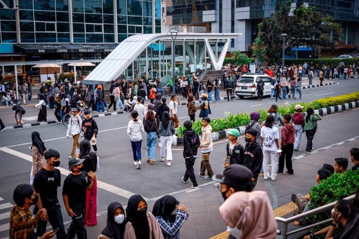 Picture of crowds of people on a street taken from a distance.