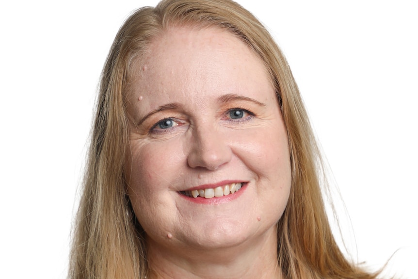 A woman with long, fair hair smiles for a corporate headshot.