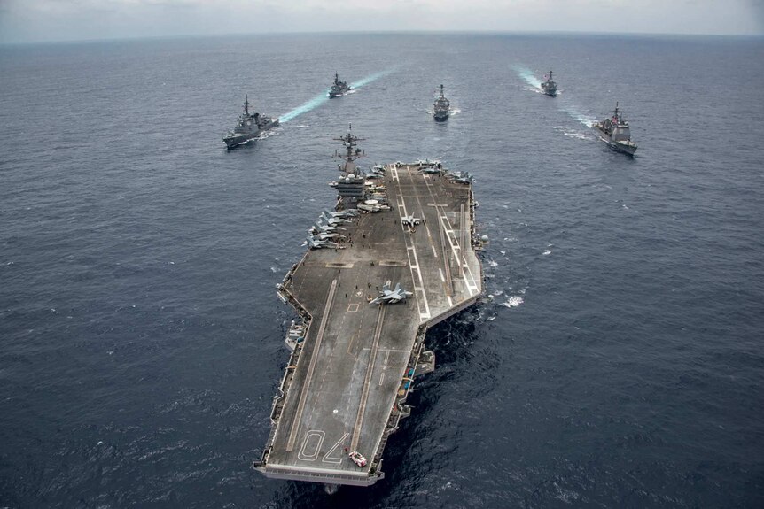 The USS Carl Vinson is flanked by Japanese and US navy destroyers