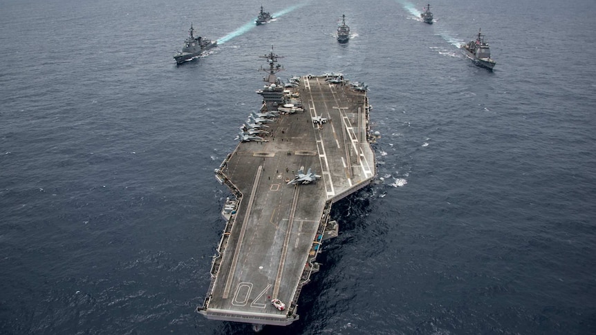 The USS Carl Vinson is flanked by Japanese and US navy destroyers