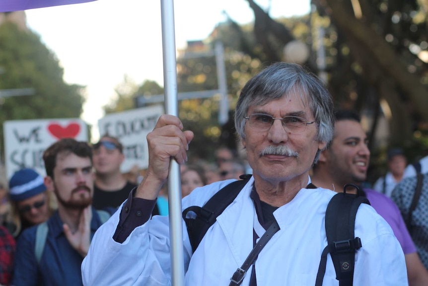 Martin Woolterding holds a sign at the march through Sydney