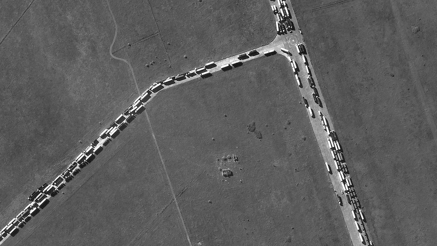 Black and white aerial view of trucks lined up on a road in traffic