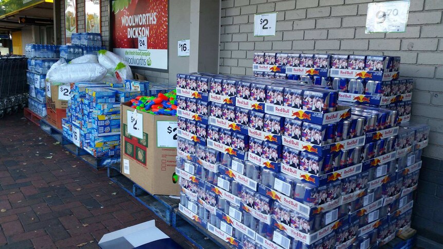 Stacks of stock on the footpath outside of Dickson Woolworths.