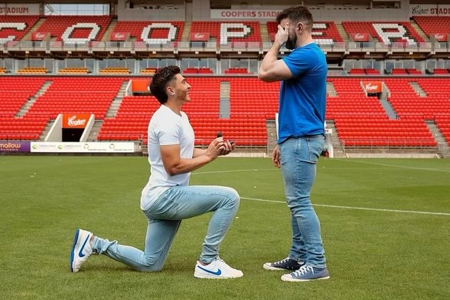 Josh Cavallo on his left knee proposing to Leighton Morrell at Hindmarsh Stadium.