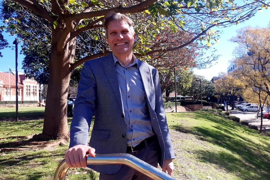 Meteorologist James Ashley stands at park on sunny day