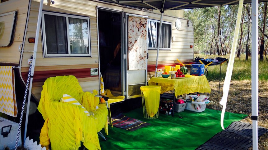 Camper trailer with yellow throw rugs and decorations