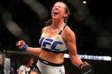 Miesha Tate celebrates after beating Holly Holm for the UFC bantamweight title