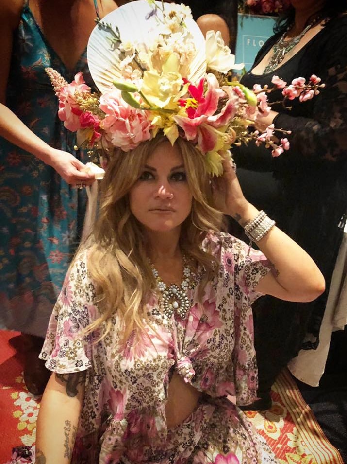 A woman wears an elaborate flower headpiece