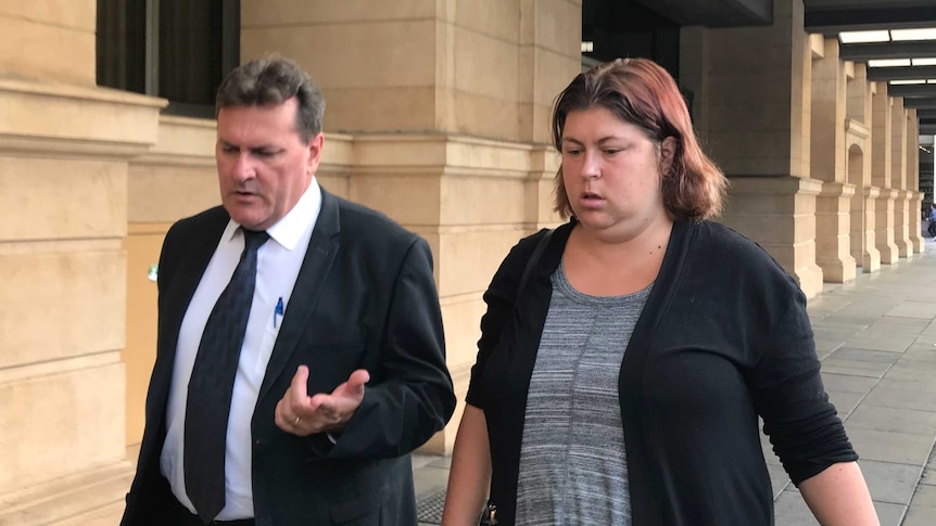A man and a woman walking outside an Adelaide court.