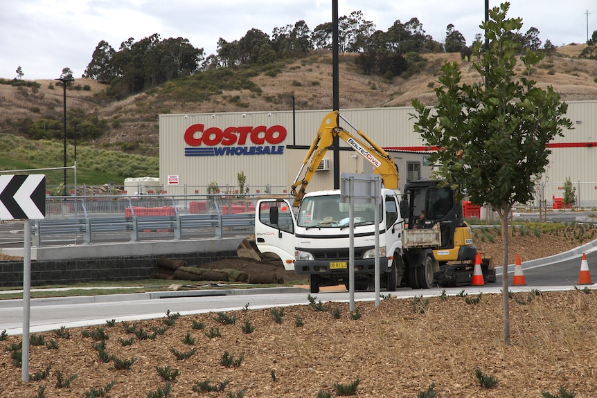 Costco 停车场入口处的挖掘机和自卸卡车